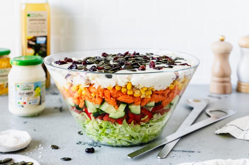 Übernacht-Schichtsalat mit Eisbergsalat, Gurken und Mais in Glasschale