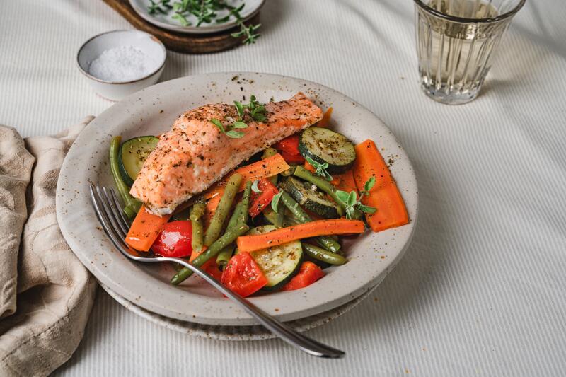 Teller mit gemischtem Gemüse und einem Stück Lachs