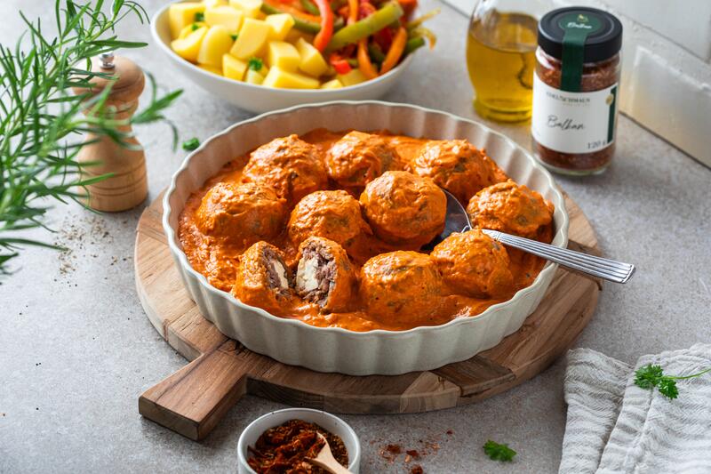 Hackbällchen mit Füllung in roter Soße in einer Auflaufform