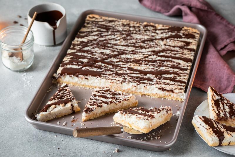Blechkuchen angeschnitten mit Kokos-Füllung und Schokoglasur