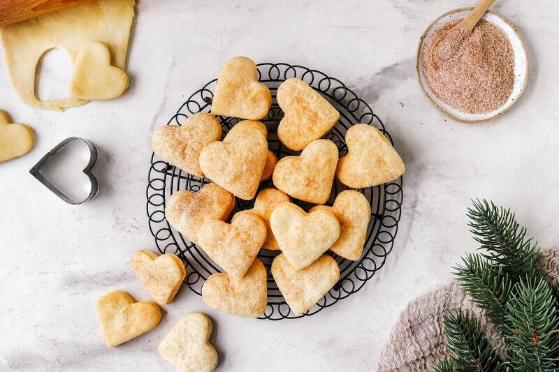 Schmandherzen mit Zimt und Zucker auf einem Teller von oben fotografiert