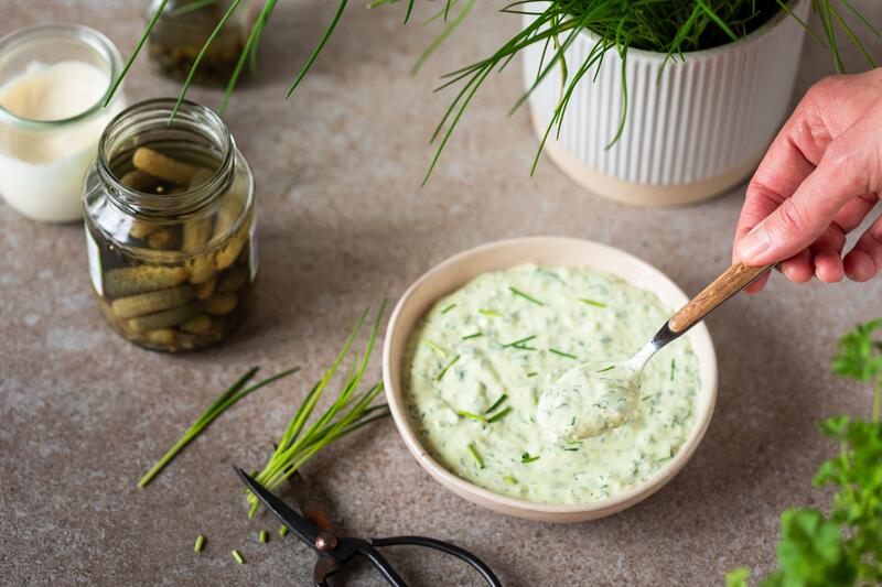 Schüssel mit Remoulade, Kräutern und Gewürzgurken