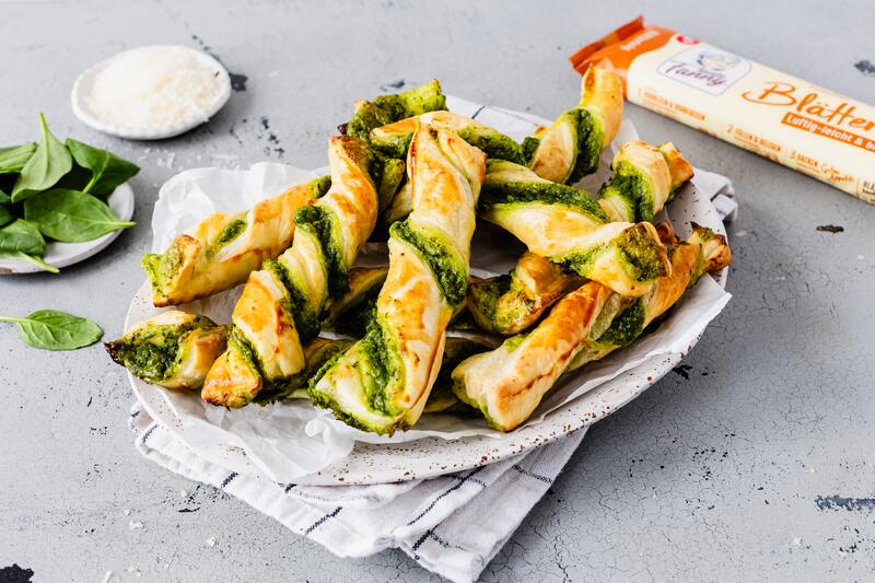 Blätterteig-Twister mit Spinat und Parmesan auf einem Teller gestapelt