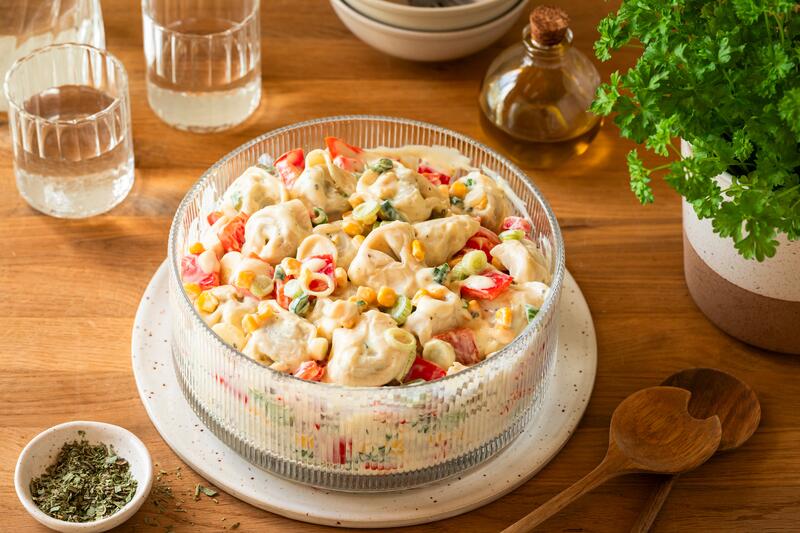 Schüssel mit cremigen Tortellini Salat mit Gemüse und veganem Soja-JOghurt