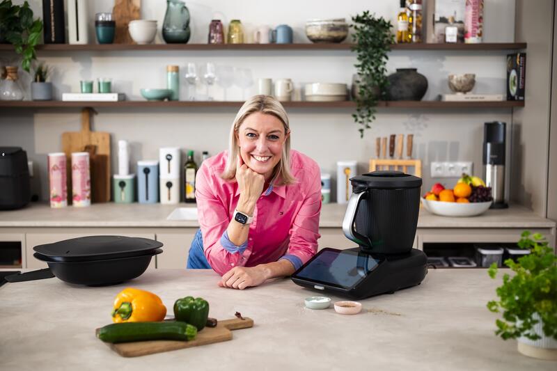Blonde Frau in einer Küche auf die Arbeitsplatte gestützt, neben dem Thermomix®