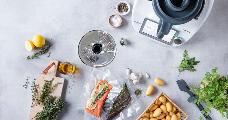 Der Thermomix® von oben fotografiert, umgeben von Fleisch, Fisch, Kartoffeln und dem Zubehör Welle