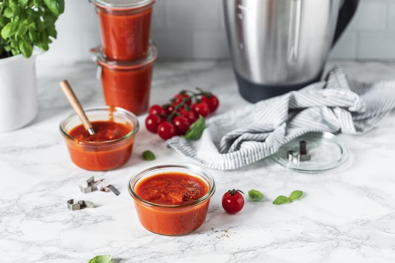 Tomatensoße in Gläschen, daneben der Mixtopf des Thermomix®