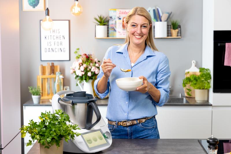 Blonde Frau mit hellblauer Bluse in Küche mit Thermomix®