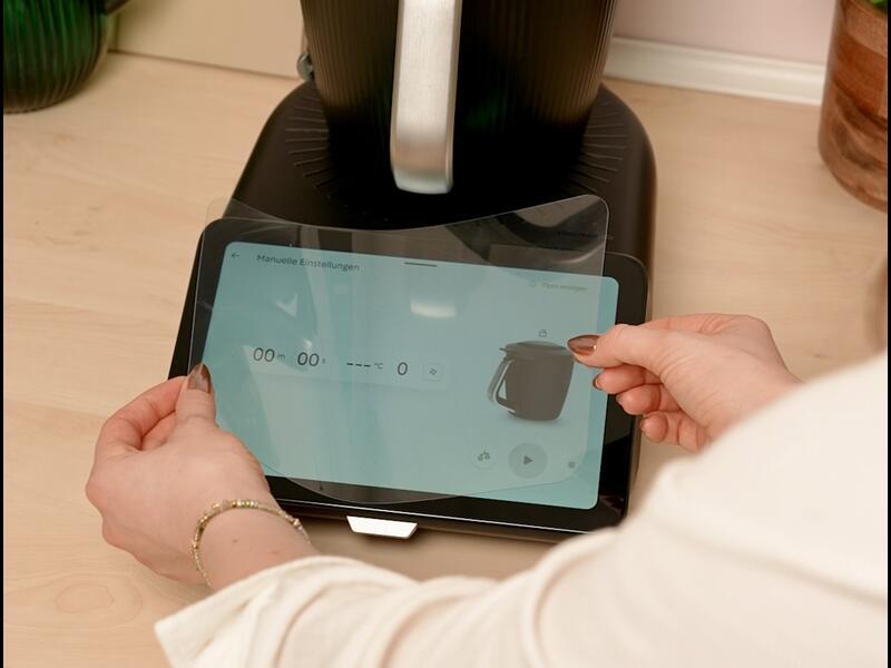 Jemand bringt eine Displayfolie am Display des Thermomix® TM7 an