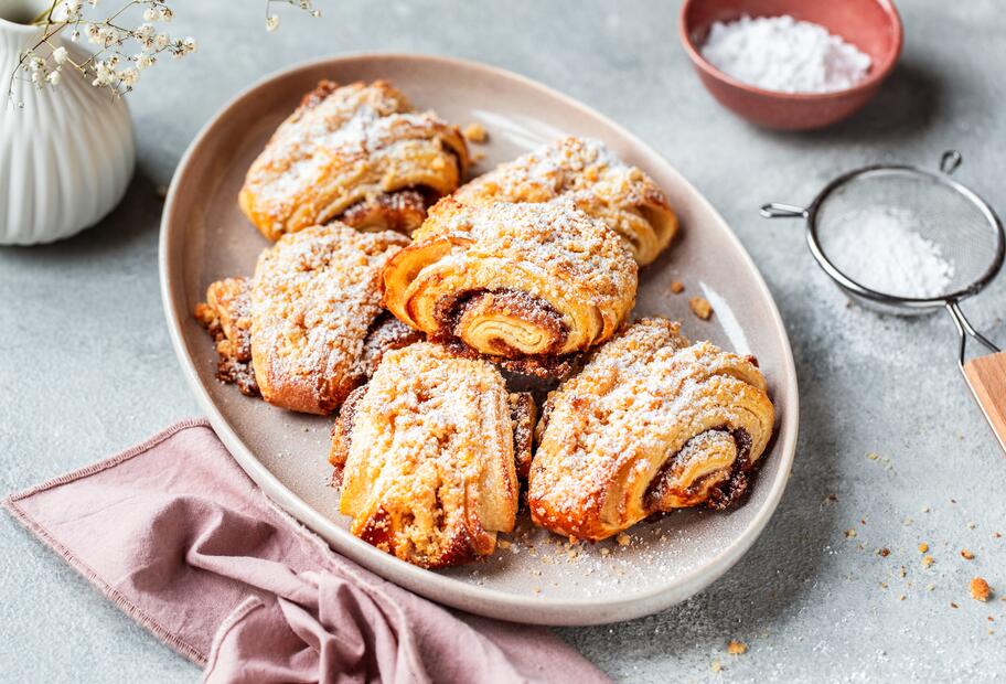 Franzbrötchen mit Streuseln und Puderzucker