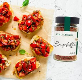 Bruschetta Brote von oben fotografiert auf Backpapier, daneben ein Glas mit Gewürz