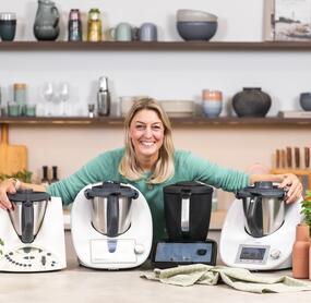 Blonde Frau mit 4 verschiedenen Thermomix® Geräten