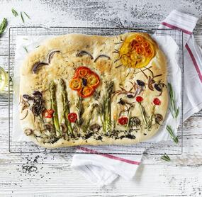 Focaccia von oben fotografiert mit Gemüse belegt, dass wie ein Garten aussieht