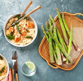 Grüner Spargel von oben fotografiert, daneben eine Schale mit Risotto