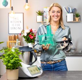 Frau in Küche hält WunderSlicer® für Thermomix® in den Händen