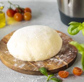 PIzzateig auf einem Holzbrett