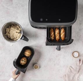 Thermomix® Mixtopf und Heißluftfritteuse von oben. Im Topf Teig, in der Fritteuse Laugenstangen