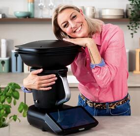 Blonde Frau umarmt den Thermomix® TM7