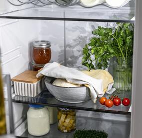 Abgedeckter Pizzateig im Kühlschrank