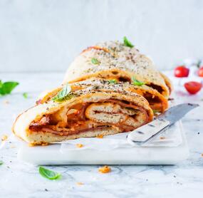 Aufgerolltes Pizzabrot mit Schinken