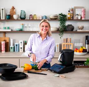 Dési steht in der ZauberTopf-Küche neben dem Thermomix® und schneidet Paprika