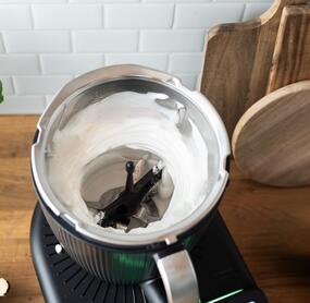 Mixtopf des Thermomix® TM7 geöffnet, darin geschlagene Sahne