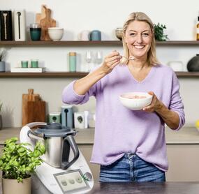 Blonde Frau in einer Küche mit einer Schale Eis