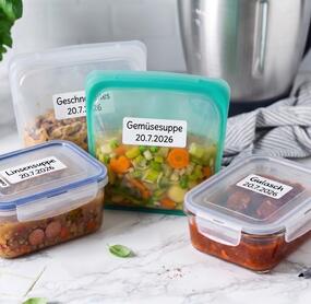 mehrere Dosen und Beutel mit vorgekochten Gerichten, im Hintergrund der Mixtopf des Thermomix®
