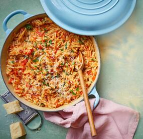 Orzo mit tomatensoße und Kräutern in einem hellblauen Topf, von oben fotografiert