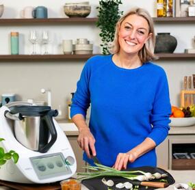 Blonde Frau in einer Küche schneidet Gemüse neben dem Thermomix®